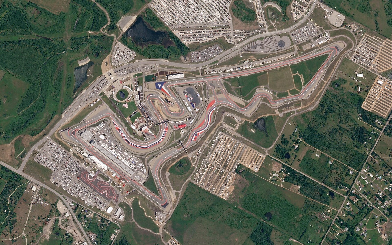 Aerial view of the Circuit of the Americas racetrack winding through surrounding fields and parking lots