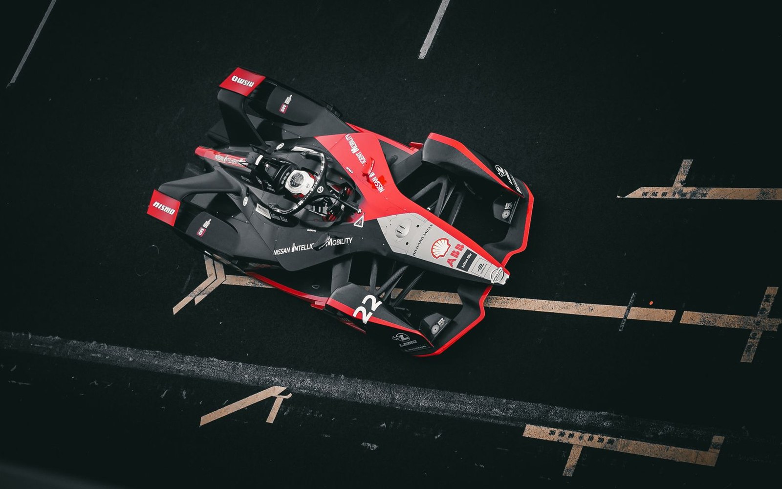 Overhead view of a black and red Nissan Formula E race car parked on track